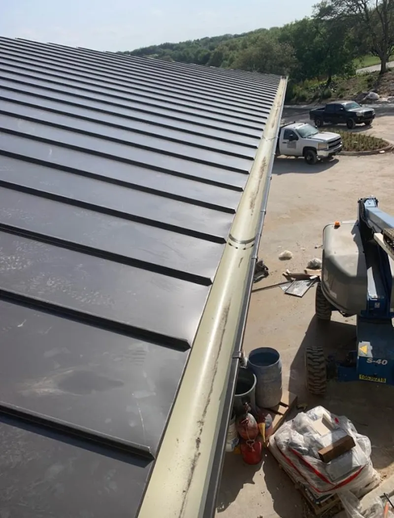 Standing seam panel and gutter detail on a metal roofing jobsite in Centerville